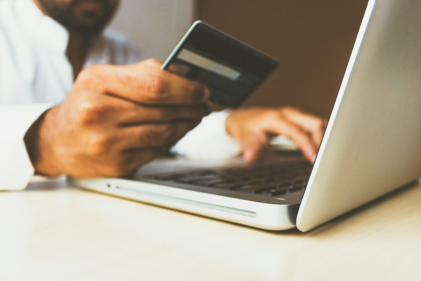Persona comprando por internet con tarjeta y laptop